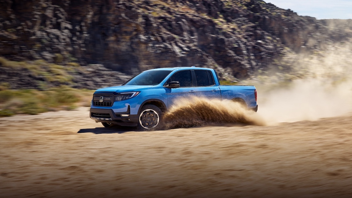 2026 Honda Ridgeline Driving through the sand spewing up around the wheels