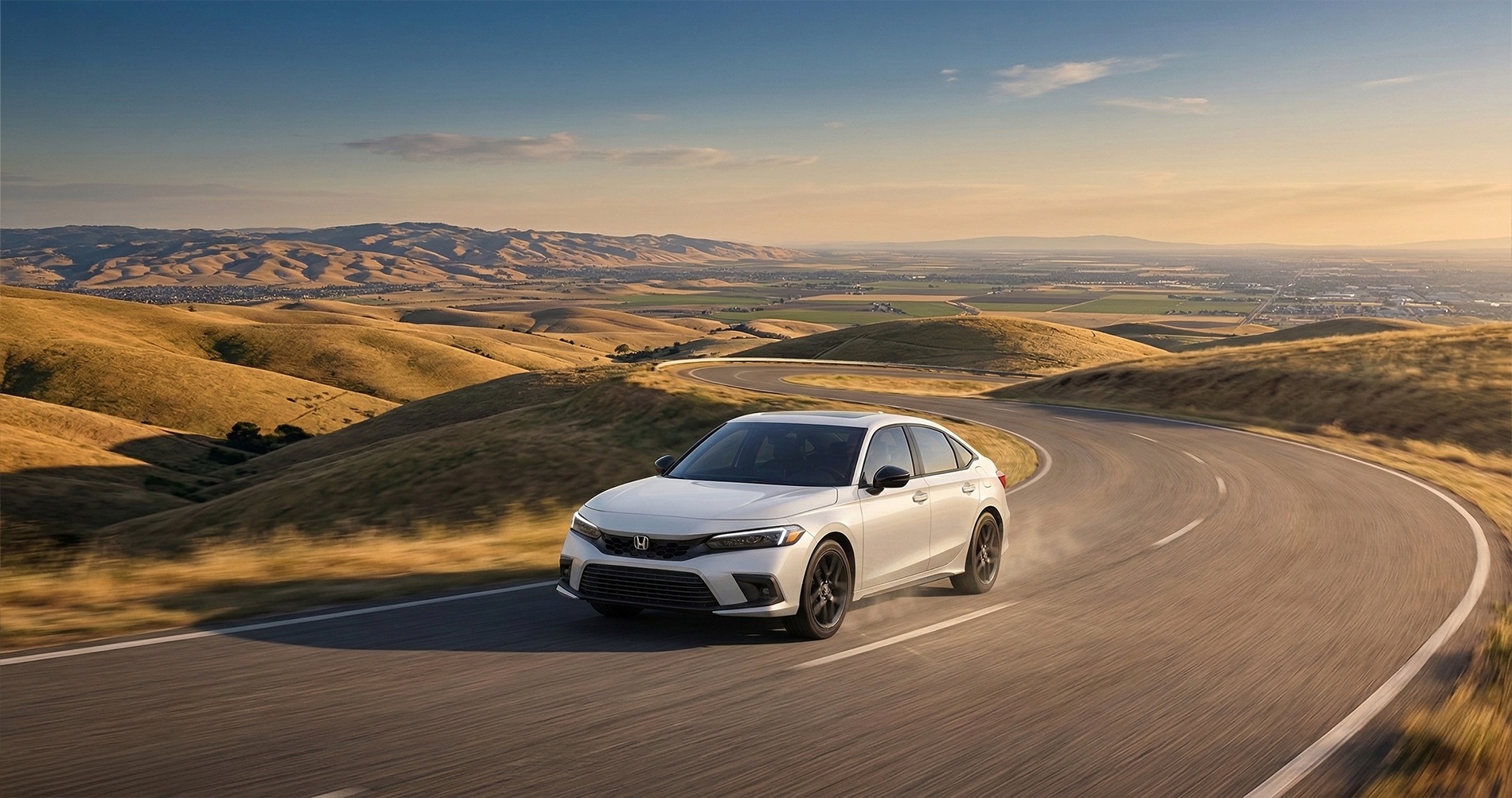 2026 Honda Civic sedan driving on winding road through Altamont Pass hills near Tracy California