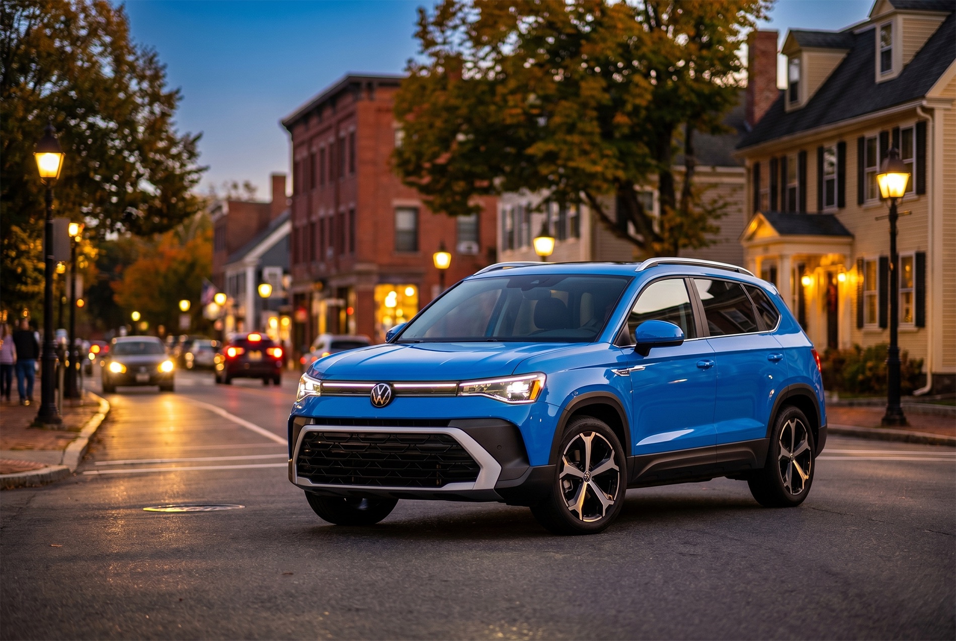 2026 Volkswagen Taos SEL trim level parked on a road in Easton MA at sunset with old brick building in the background