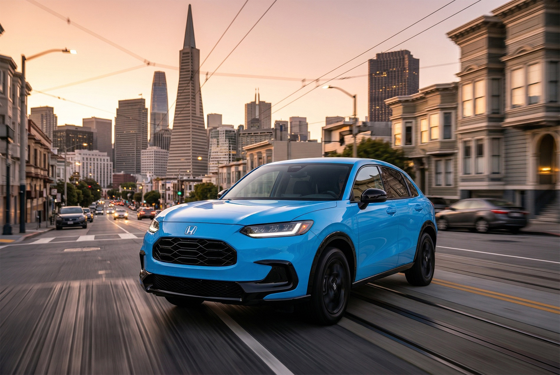 2027 Honda HR‑V driving down a San Francisco street at sunset, with warm light reflecting off surrounding buildings and the Transamerica Pyramid visible in the background.
