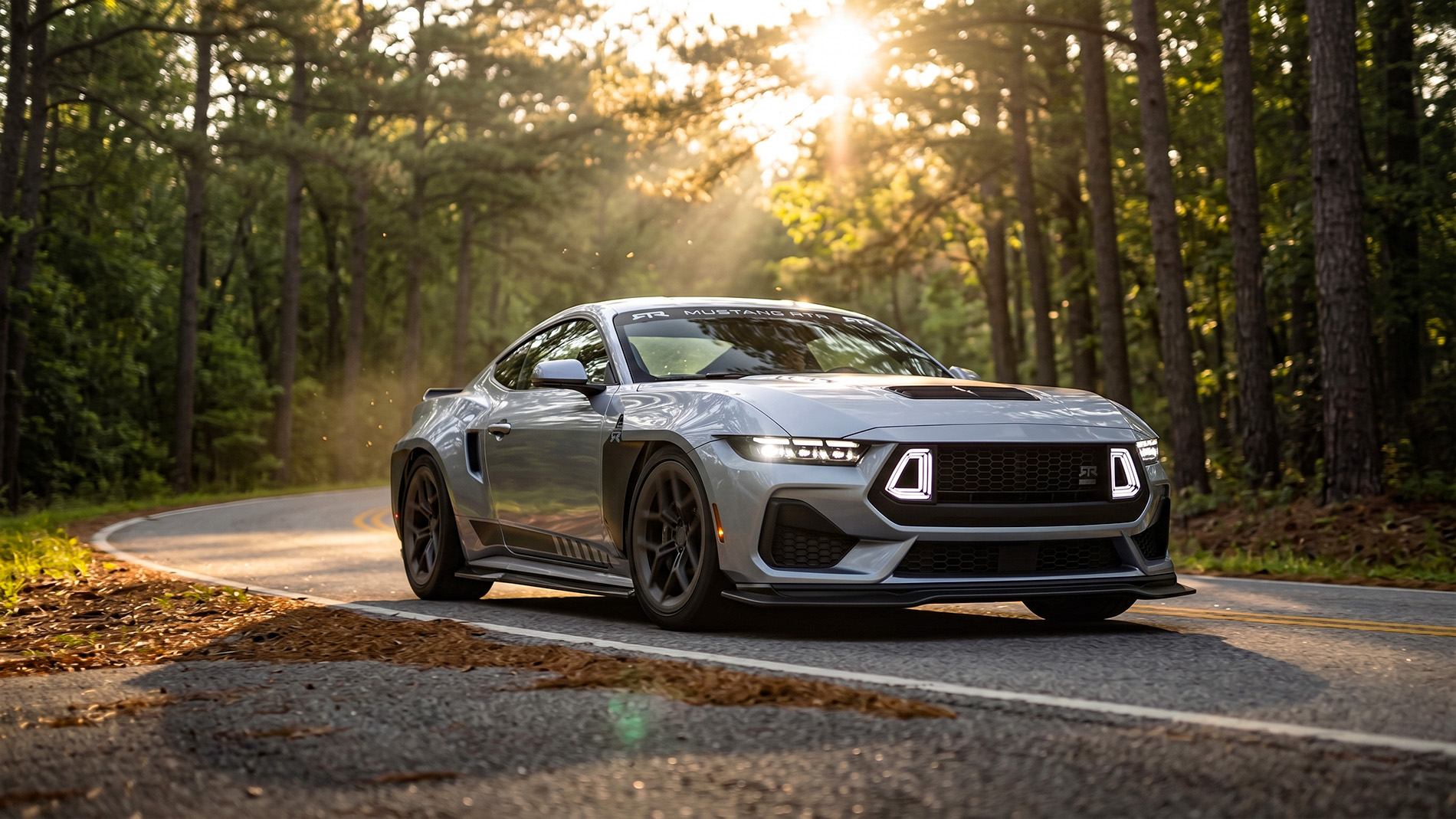 RTR Mustang Spec 5 driving on a paved corner through a forest with the sun rising through the trees