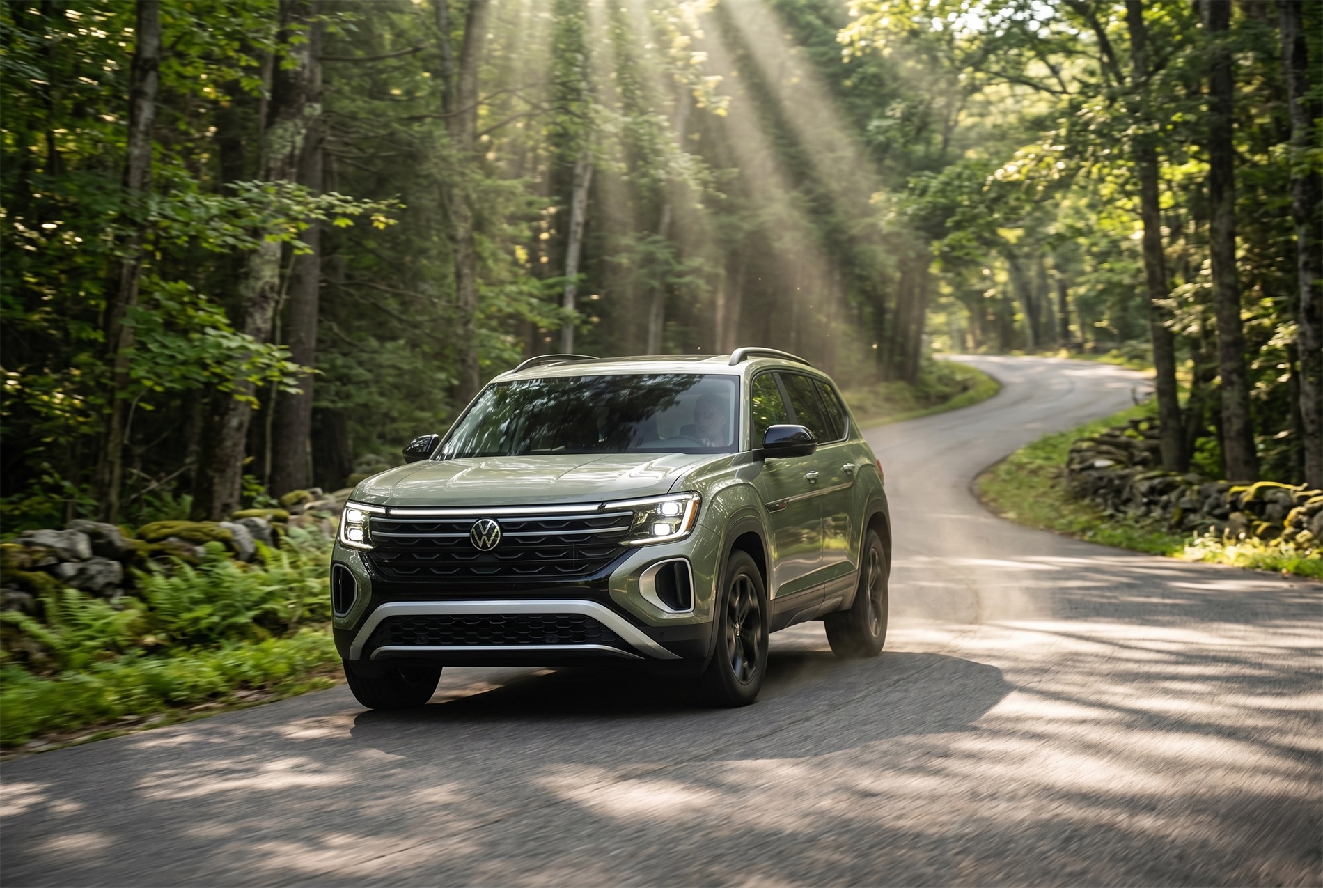 2026 Volkswagen Atlas Peak Edition driving on a wooded rural road