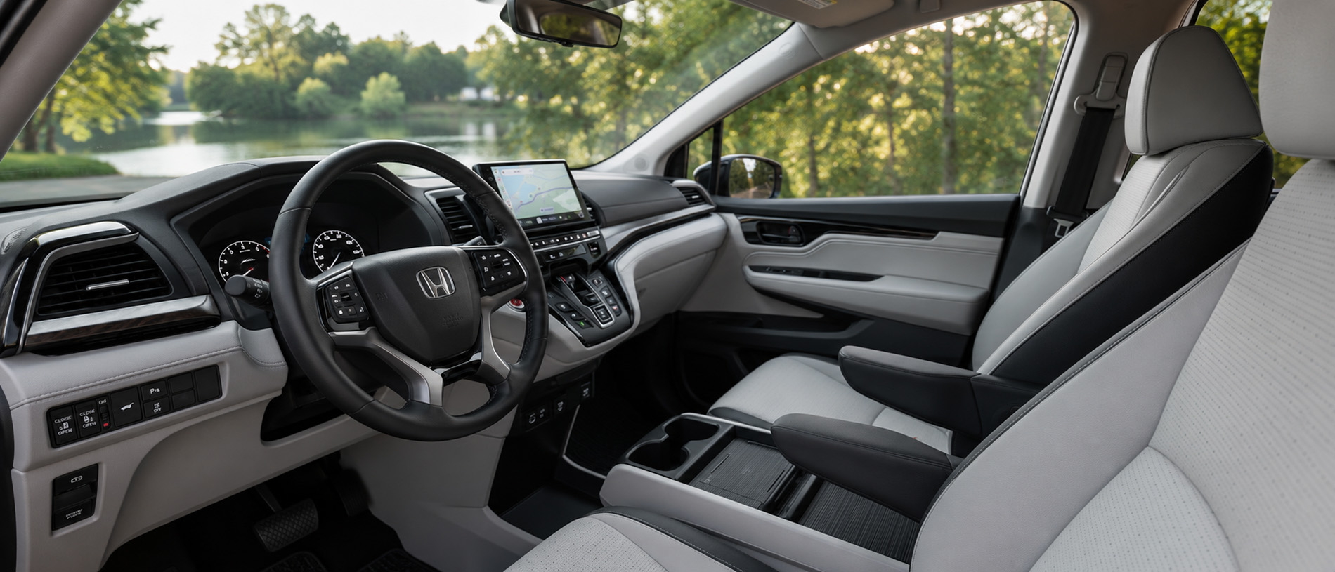 Light gray and black cabin with touchscreen navigation and lake views, emphasizing comfort and technology.