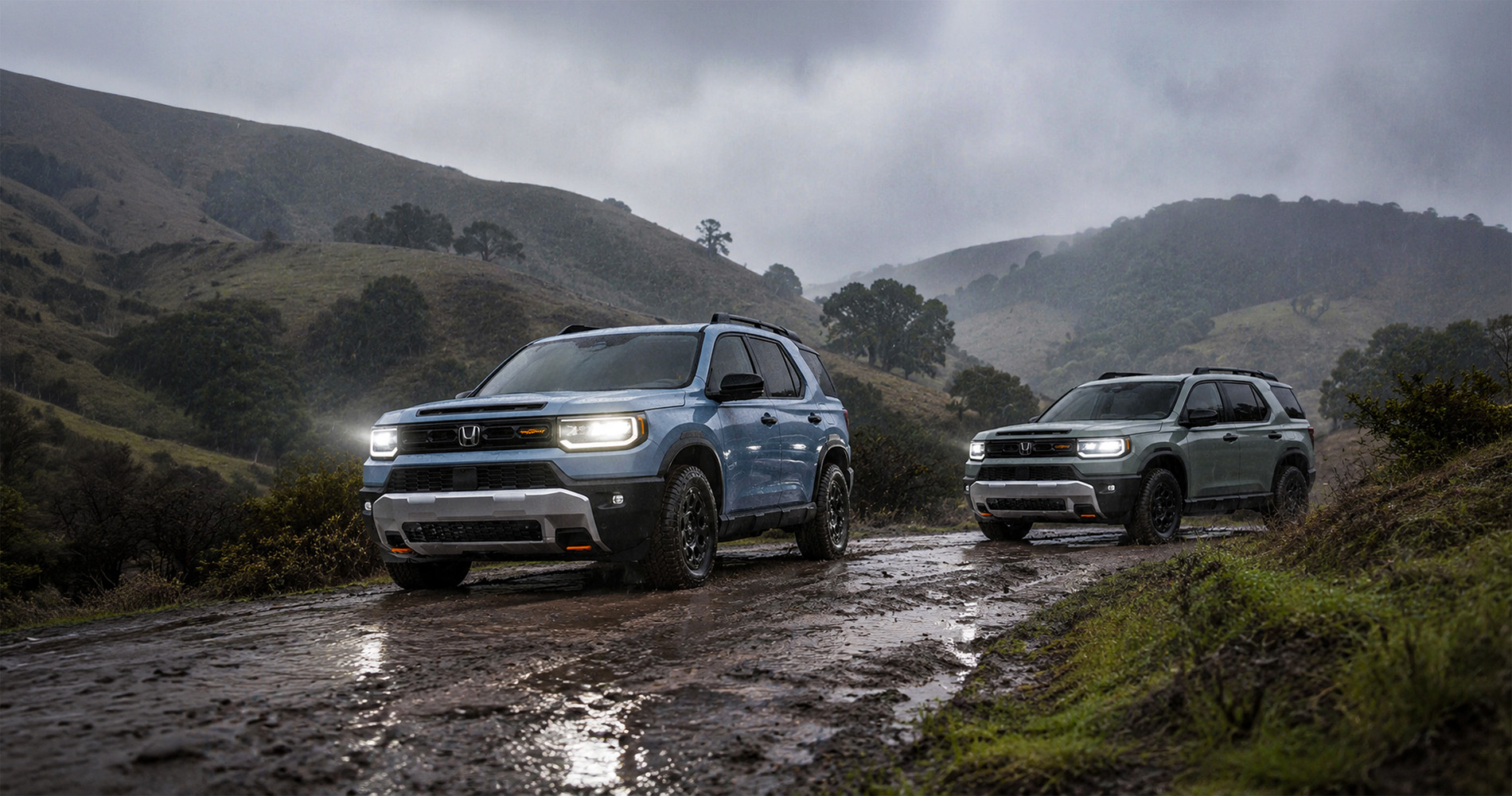 Two 2026 Honda Passport TrailSport SUVs driving through a muddy trail surrounded by rolling hills and trees near Pittsburg, California, under a cloudy sky with headlights illuminating the wet terrain, highlighting the SUV’s off-road performance and rugged design.