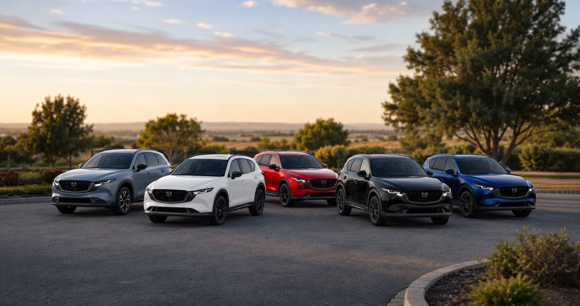 Five CX‑5 SUVs in gray, white, red, black, and blue parked outdoors at sunset, showcasing trim variety.