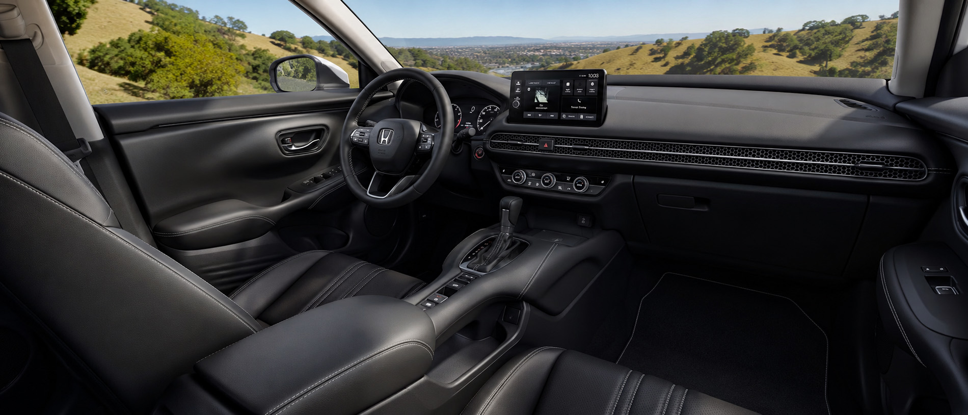     2027 Honda HR-V EX-L interior with touchscreen, front seats, and a rural East Bay view through the windshield.