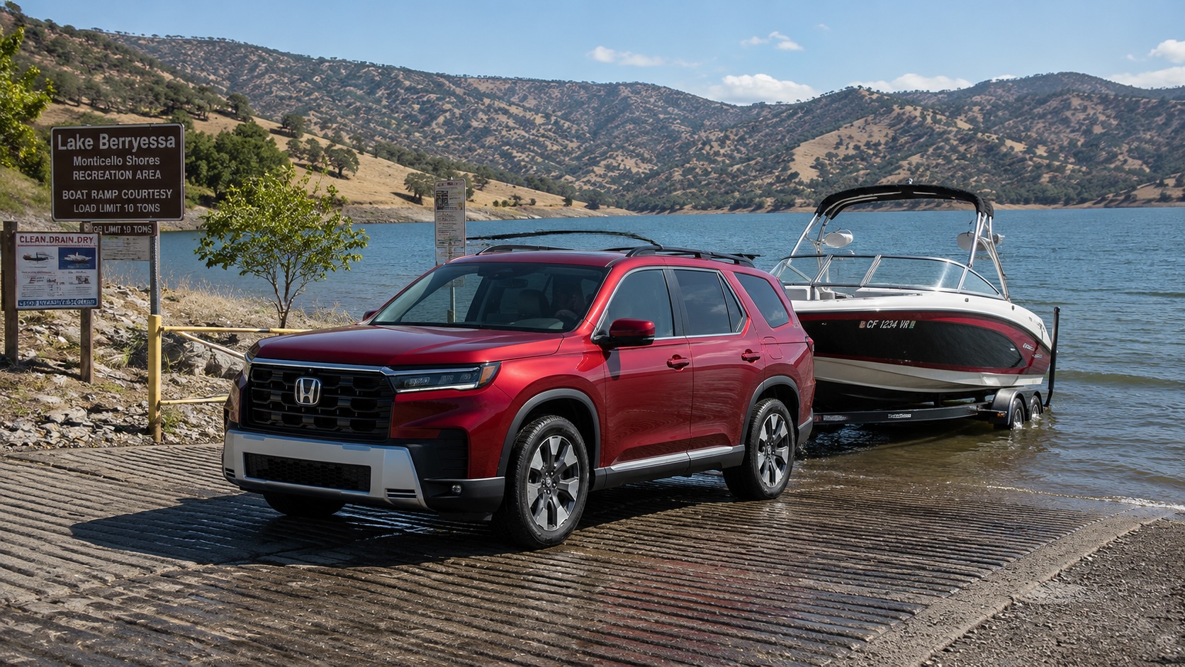 Red Honda Pilot backing a white and red boat down a ramp at Lake Berryessa with rolling hills and water in the background.