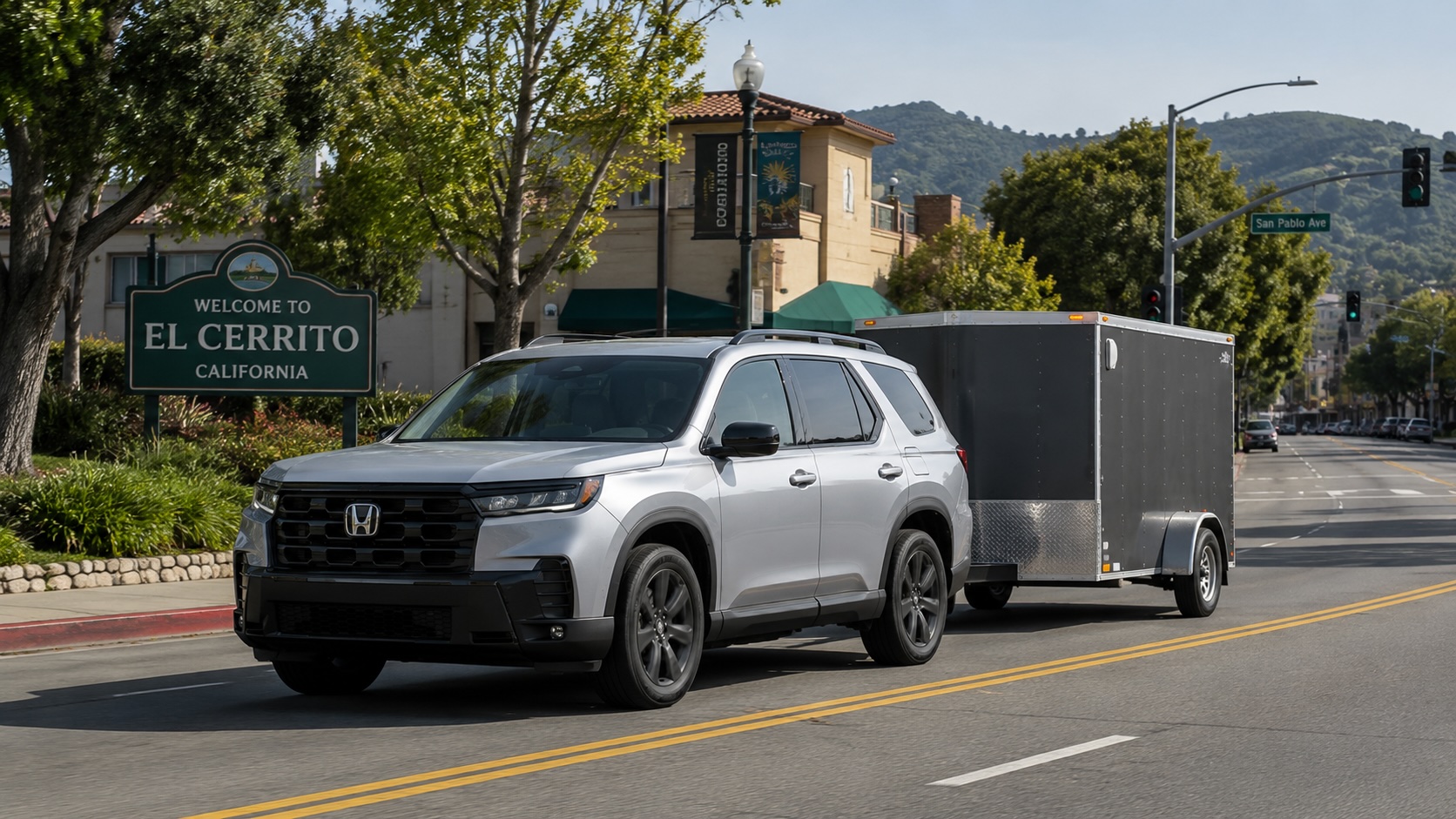 Silver Honda Pilot towing a 12-foot enclosed trailer through El Cerrito near San Pablo Avenue with green hills in the background.