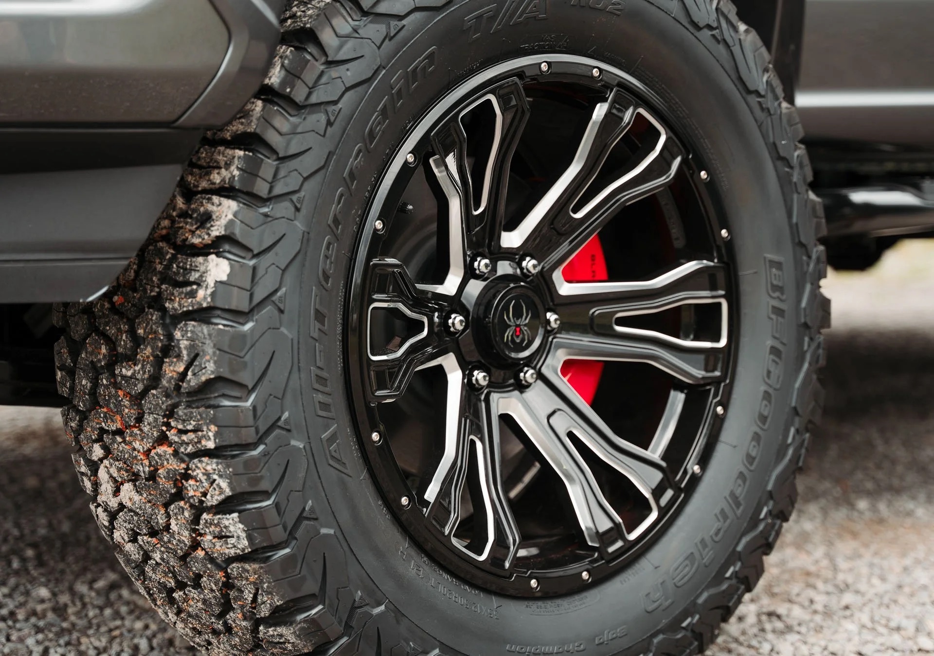 Custom Black Widow wheels and all-terrain tires on a lifted Ford truck