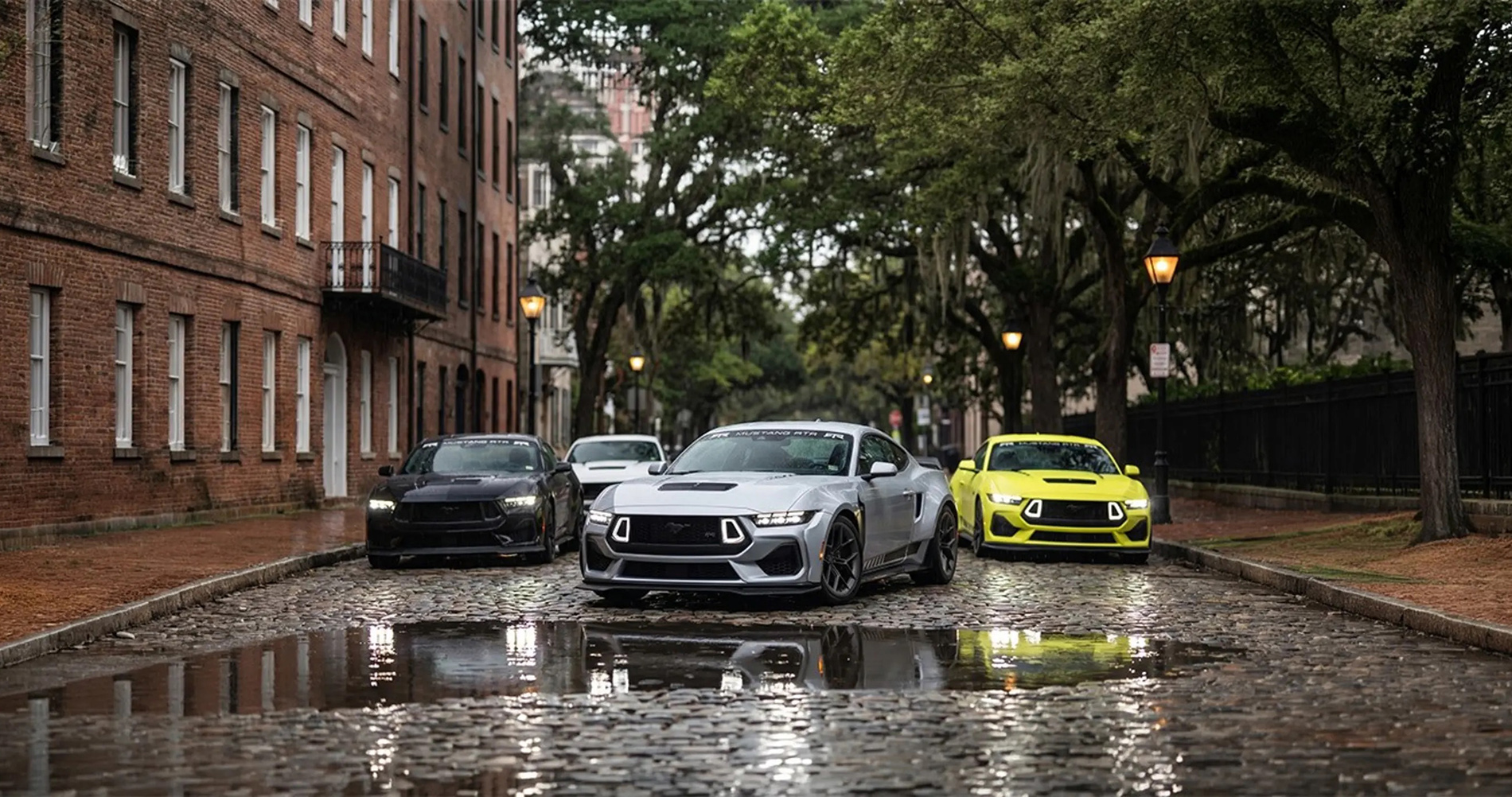 RTR Mustang models parked on a wet cobblestone street in historic Savannah, Georgia.