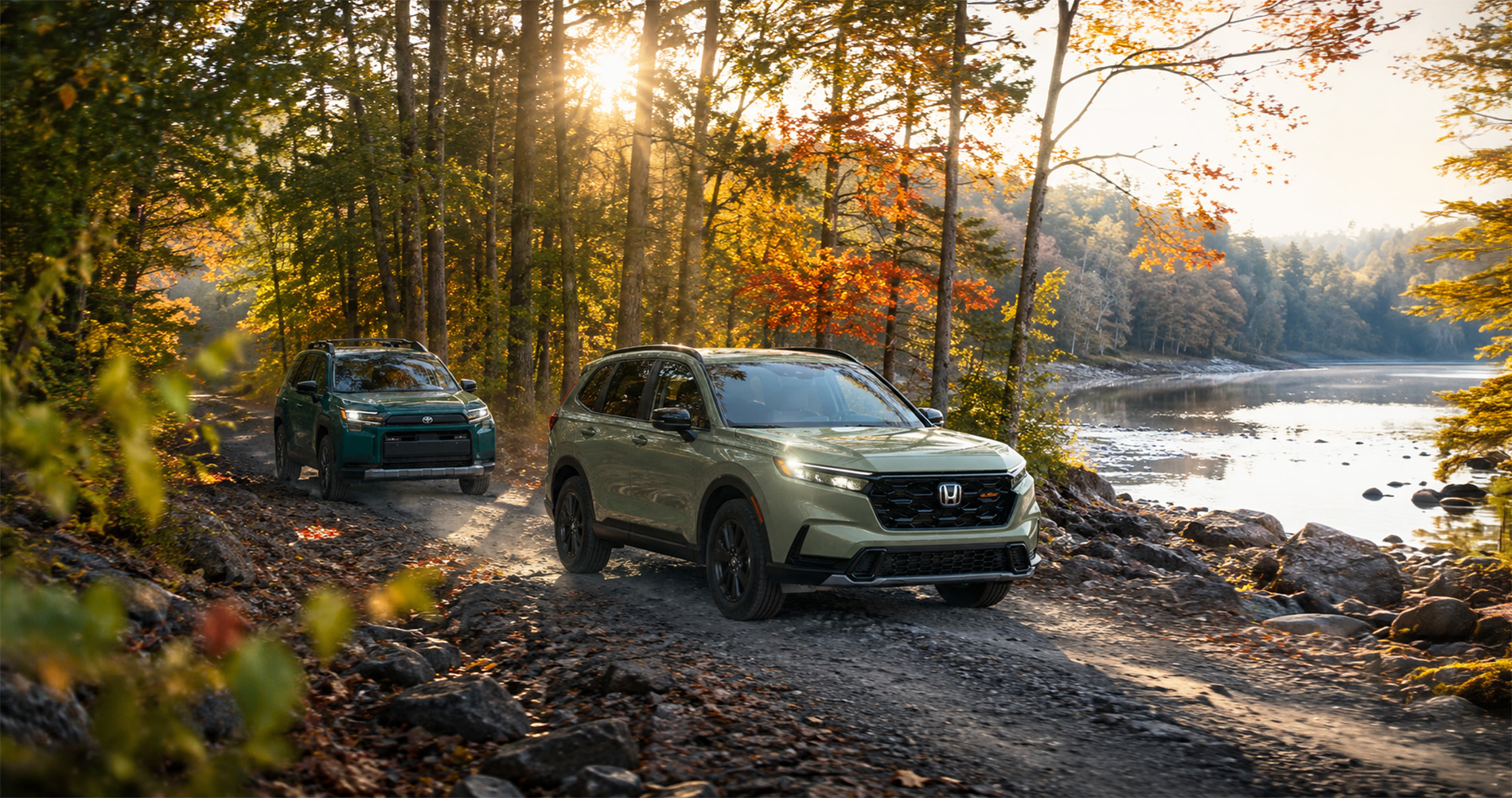 Honda CR-V and Toyota RAV4 compact SUVs on a forest trail beside a lake at sunrise, highlighting outdoor-oriented compact SUV styling.