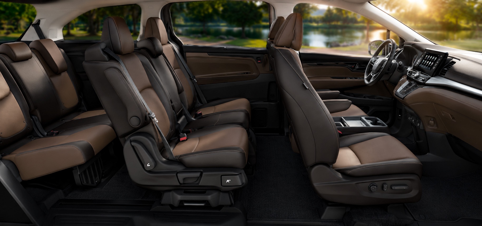 Three-row cabin with brown and black leather seats, touchscreen display, and park view through windows.