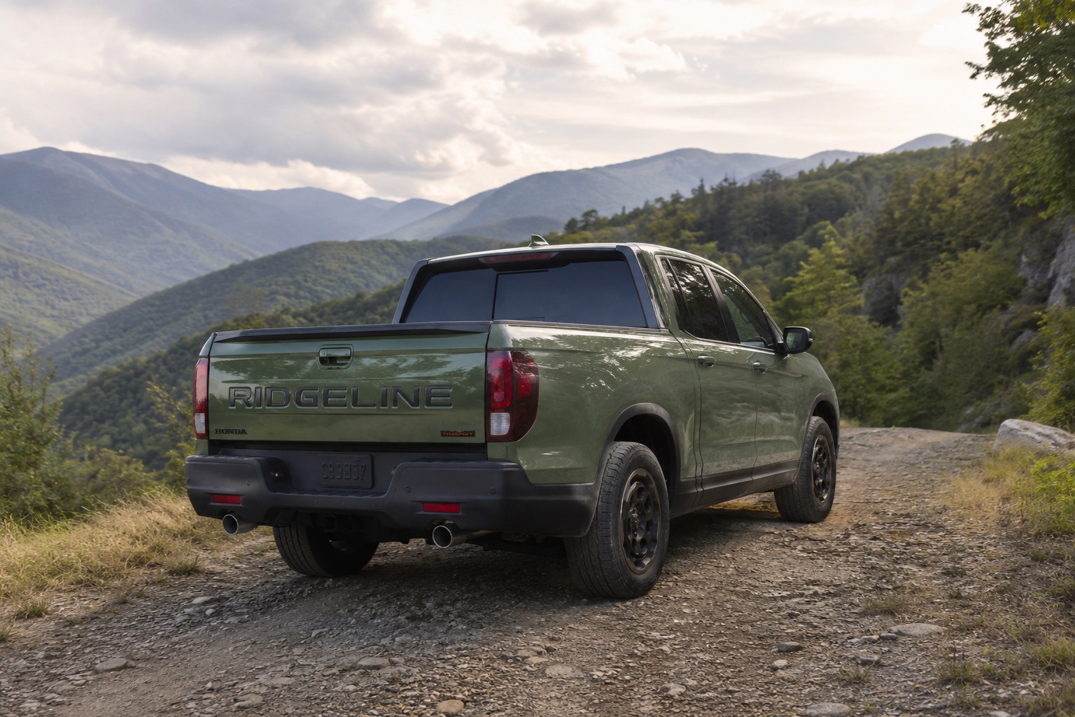 2026 Honda Ridgeline TrailSport driving on a rocky mountain trail with an open truck bed and forested New York mountain scenery in the background.
