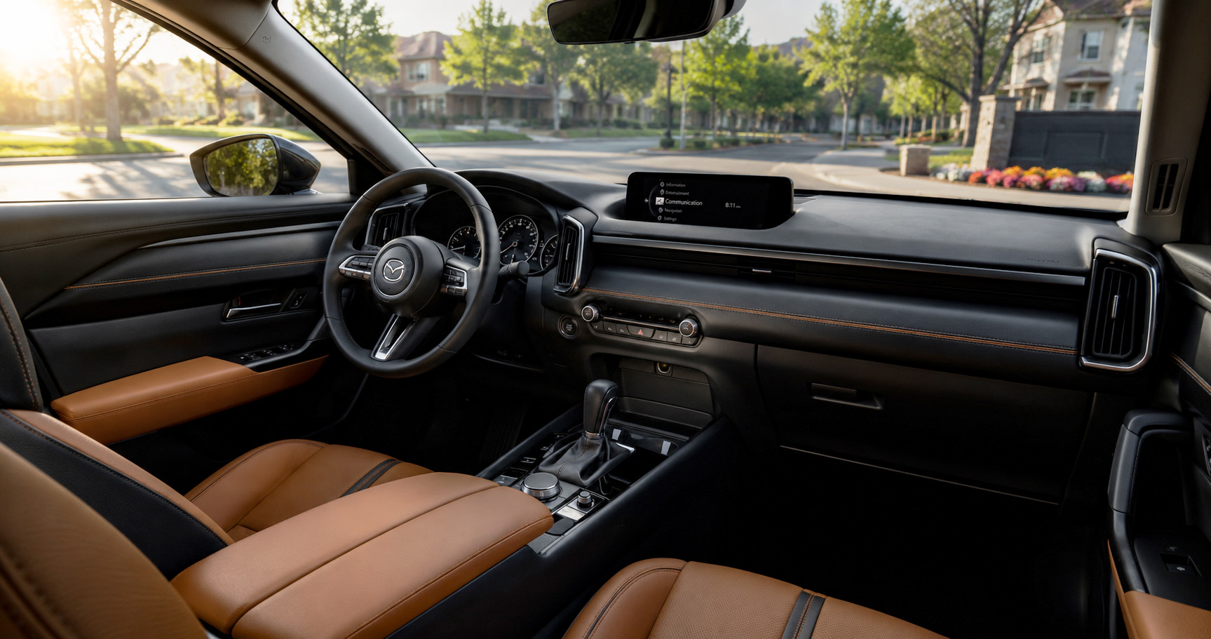Brown and black Mazda CX-50 cabin with touchscreen display and leather seats showcasing modern design and comfort.