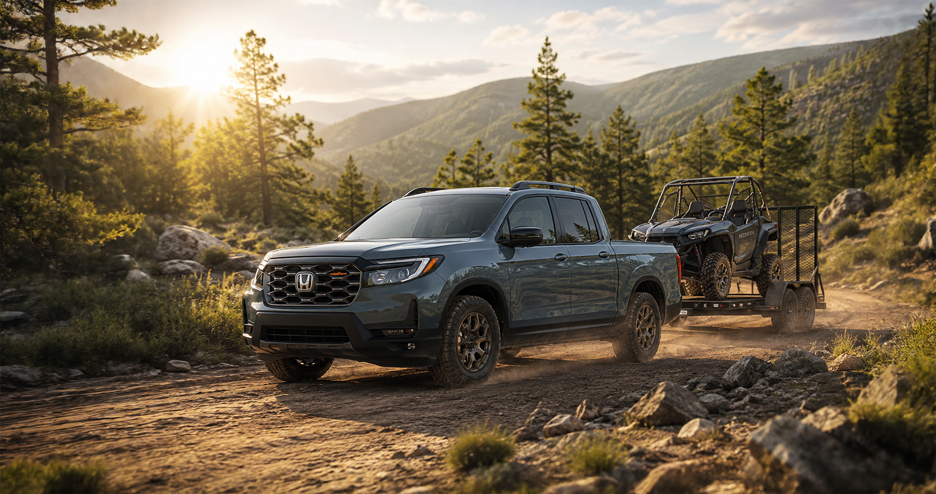 Gray Honda Ridgeline TrailSport towing off road vehicle on dirt mountain road at sunrise emphasizing rugged capability.