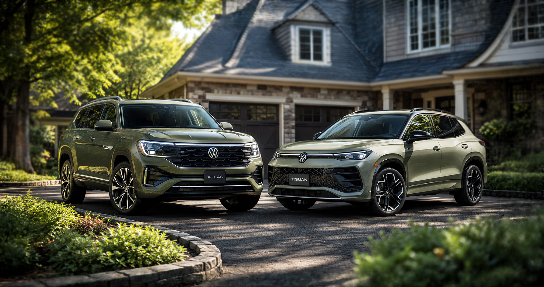 Green Volkswagen Atlas and Tiguan SUVs parked together in a Massachusetts driveway to highlight their size and styling differences.