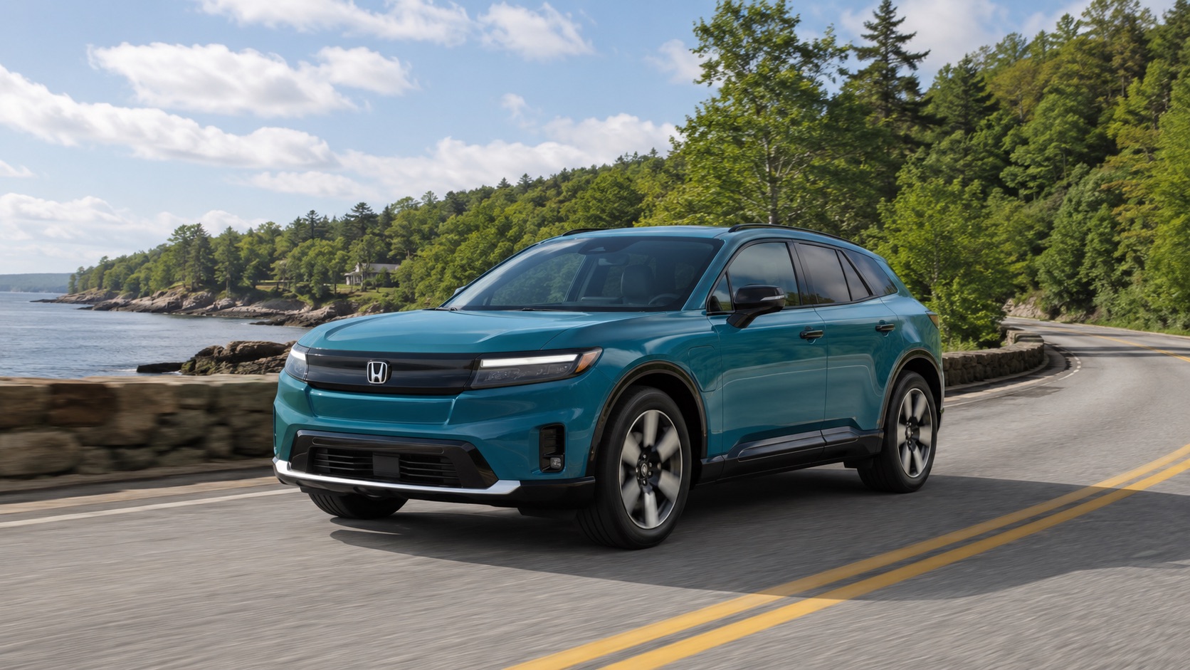 Teal 2026 Honda Prologue Touring driving along a scenic coastal New England road with water, trees, and rocky shoreline in the background.