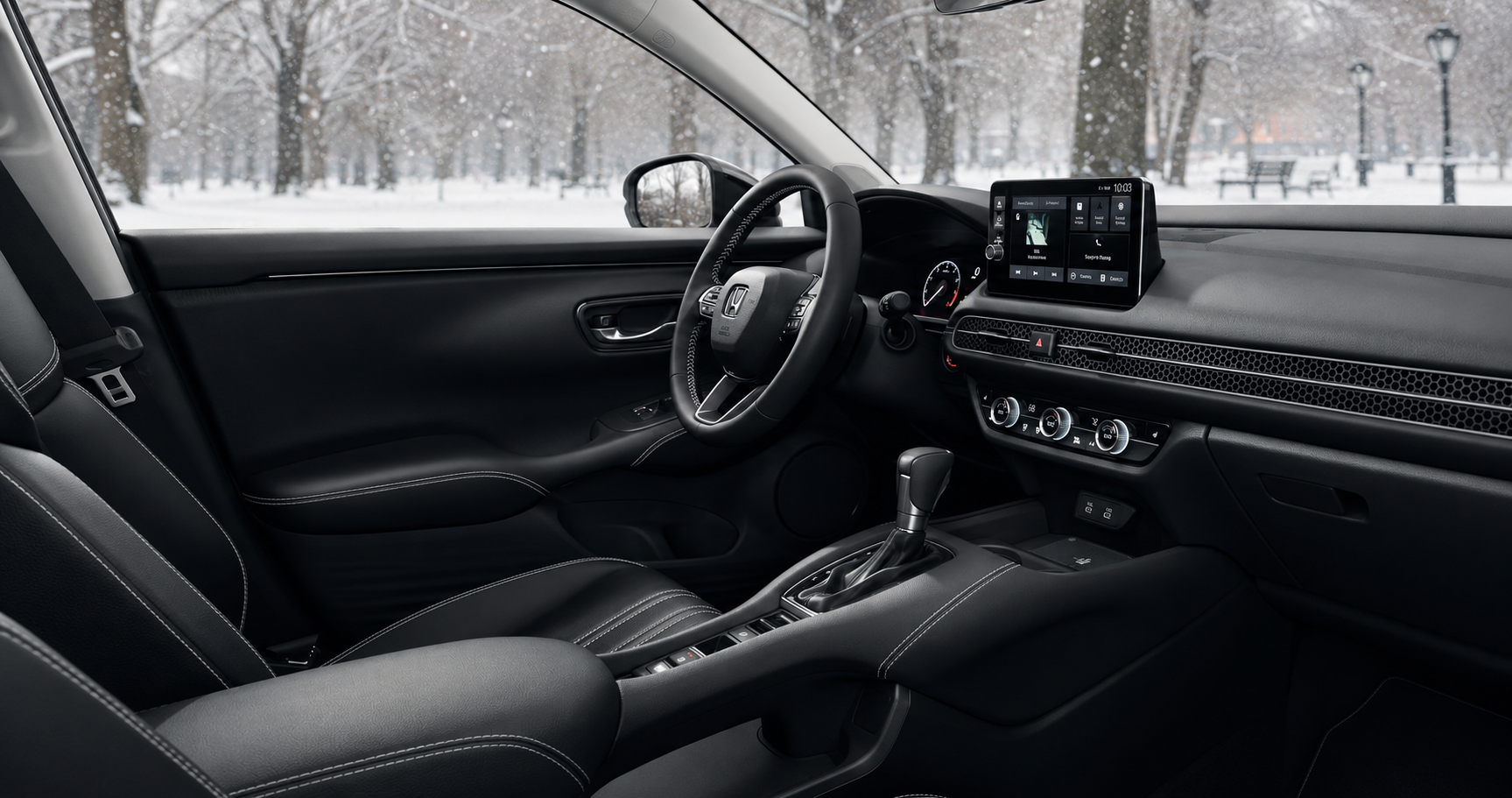 Black Honda HR‑V cabin with touchscreen display and leather seats showing dashboard design and winter scenery outside.