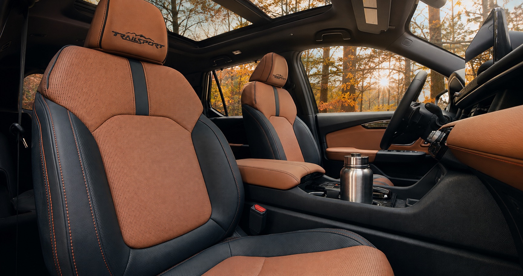 Brown and black Honda Passport TrailSport cabin with embroidered seats panoramic sunroof and stainless steel bottle emphasizing premium adventure design.