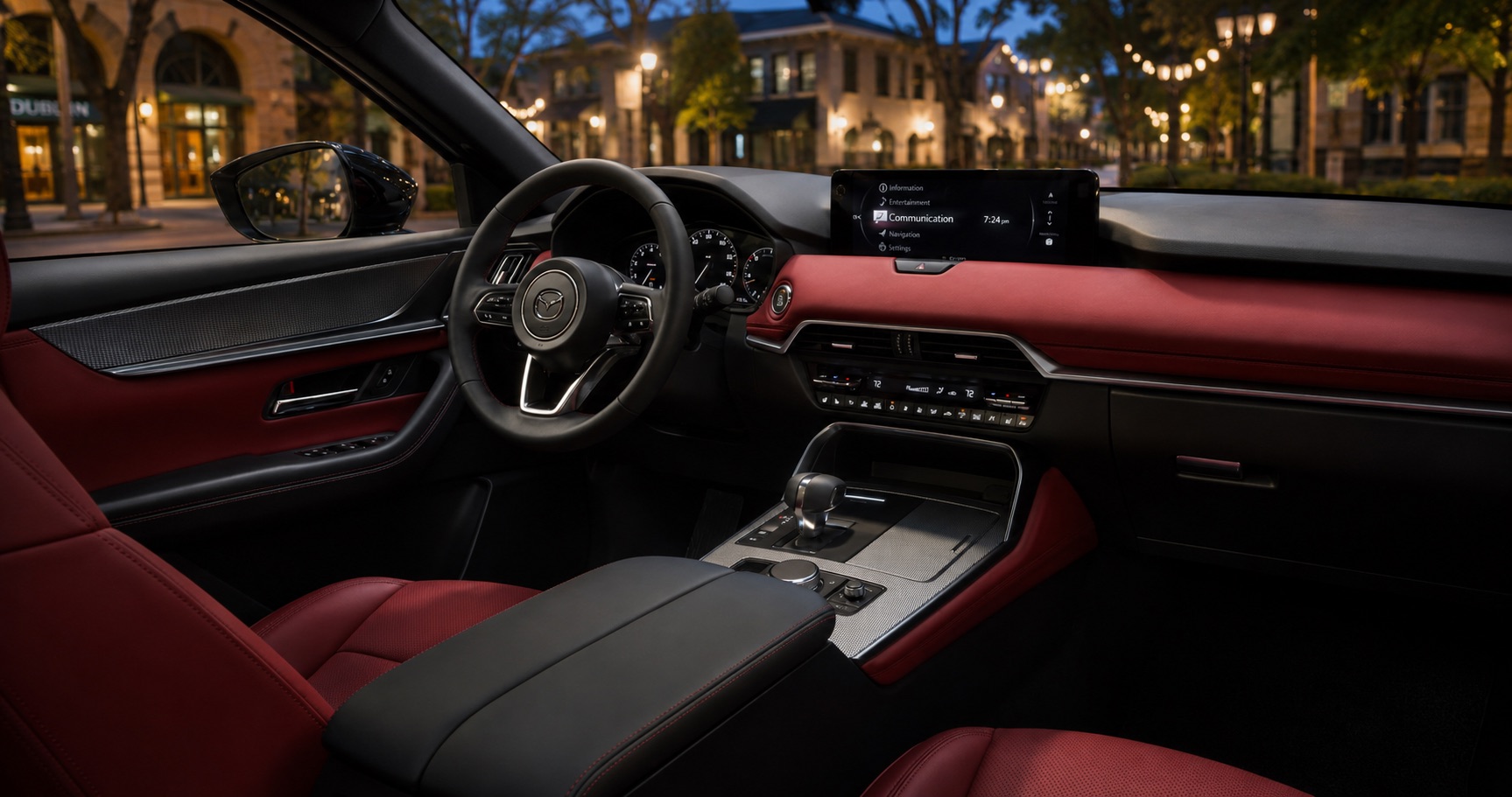 Mazda CX‑70 cabin with red leather seats and dashboard black steering wheel and digital display showing refined design and evening lighting.