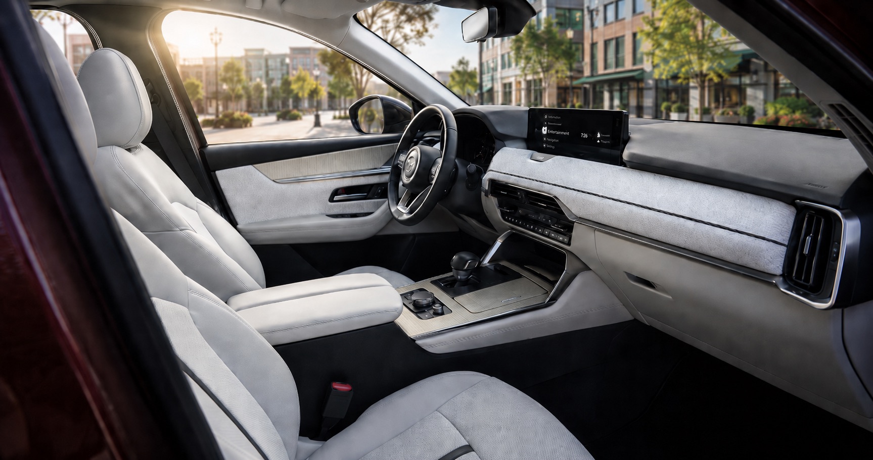 Mazda CX‑90 cabin with white leather seats and dashboard showing steering wheel center console and infotainment display in daylight.