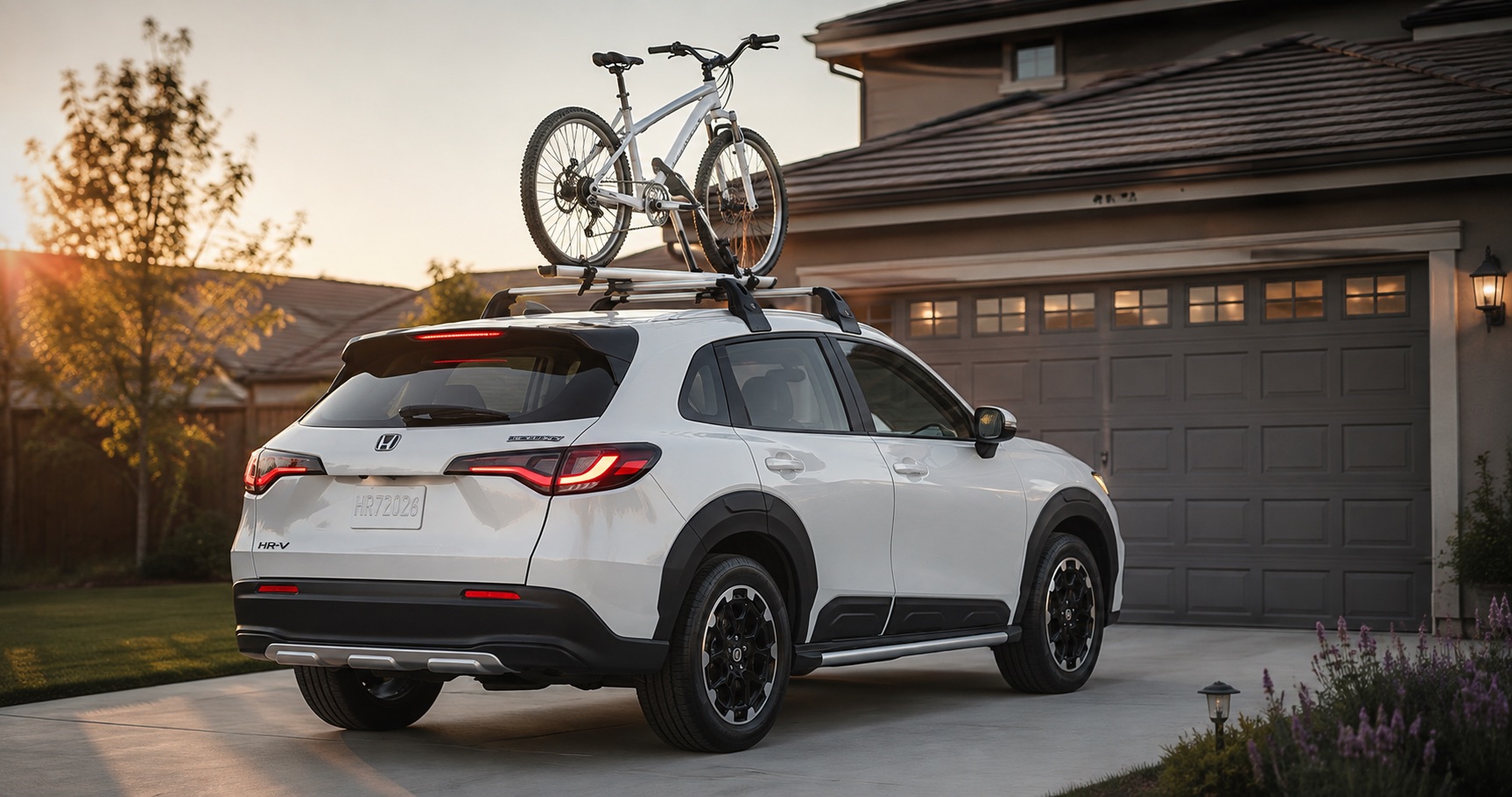 White Honda HR-V parked in driveway with bicycle mounted on roof rack at sunset highlighting rear styling and adventure ready design.