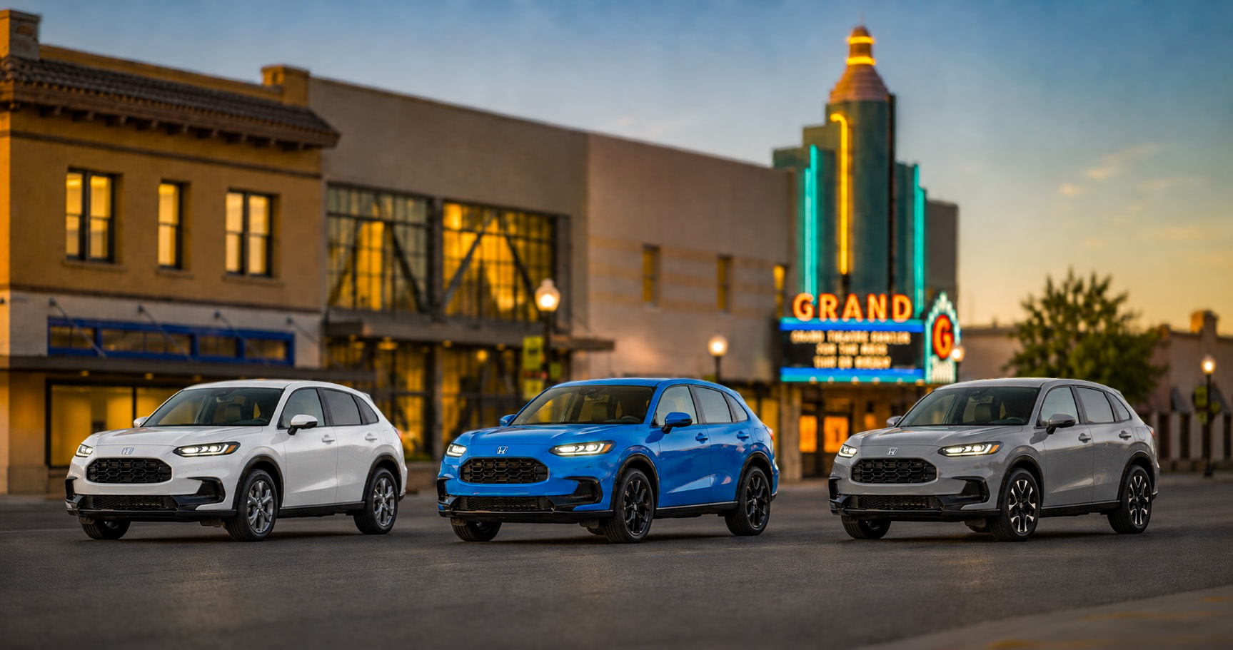 Three Honda HR-V SUVs in gray blue and white parked near Grand Theatre Center for the Arts in downtown Tracy showcasing full trim range and color options.