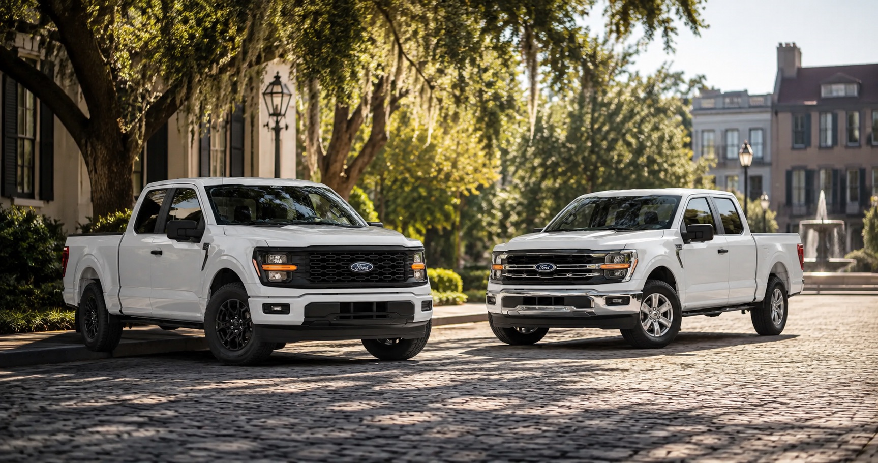 Two white Ford F‑150 trucks, STX and XLT, parked on a quiet tree lined street in early morning light.