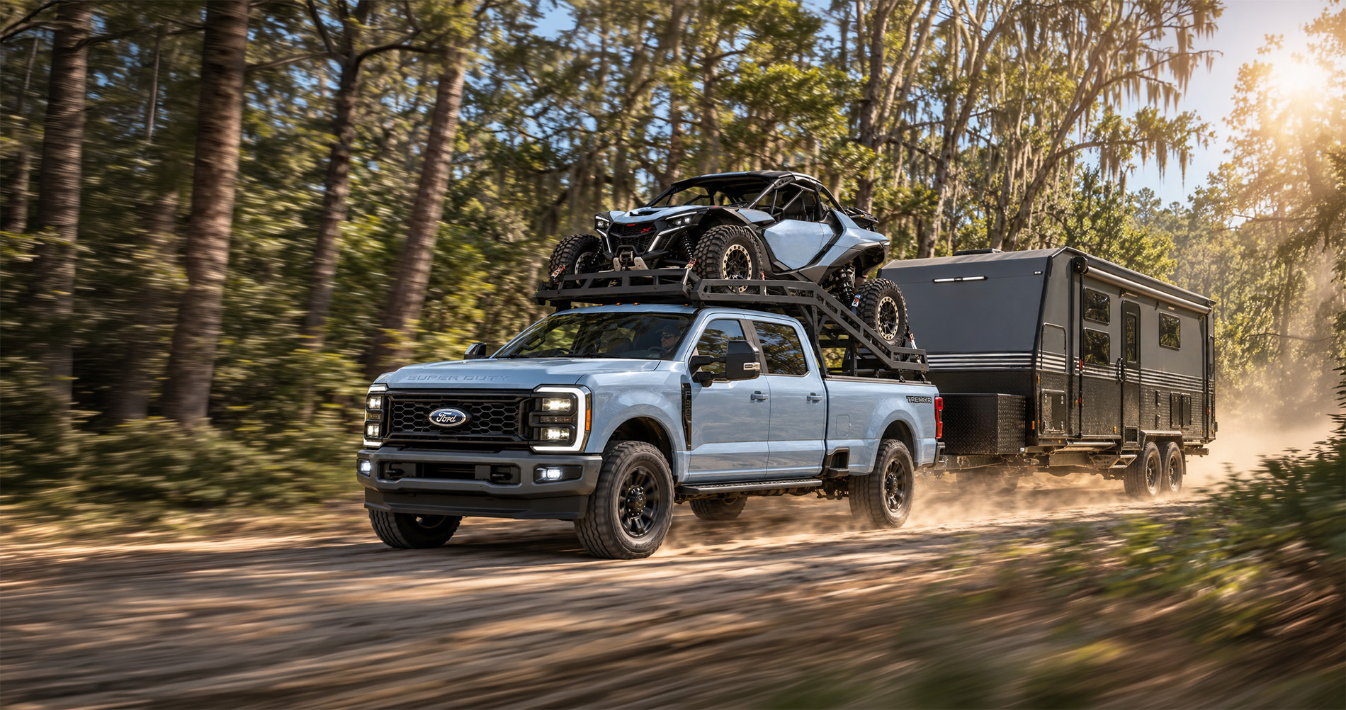 2027 Ford F-350 Lariat towing an off-road travel trailer with a side-by-side in the forest outside of Savannah, GA