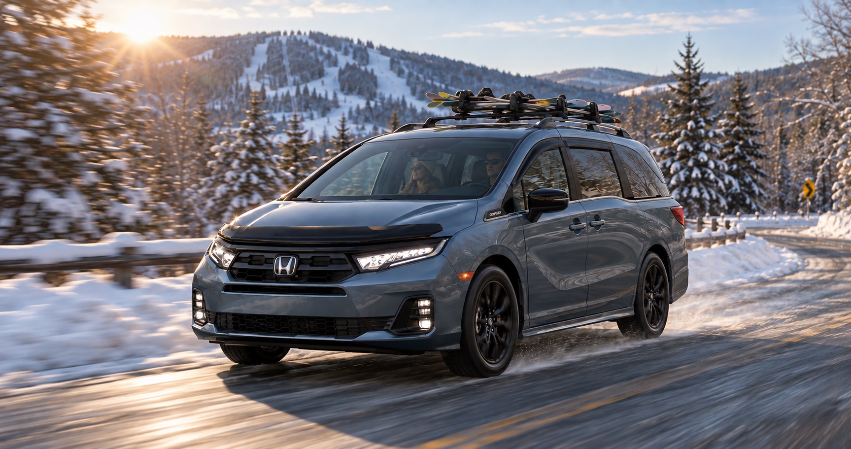 2027 Honda Odyssey Sport-L driving on a snowy road with skis mounted on the roof near Troy, NY