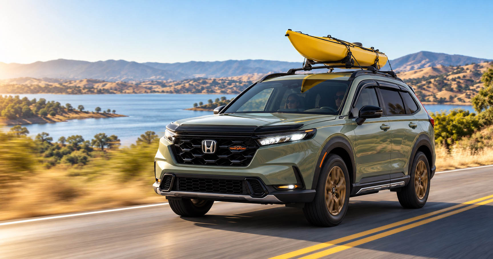 2027 Honda CR-V TrailSport Hybrid with a yellow kayak driving beside a reservoir near Tracy, CA