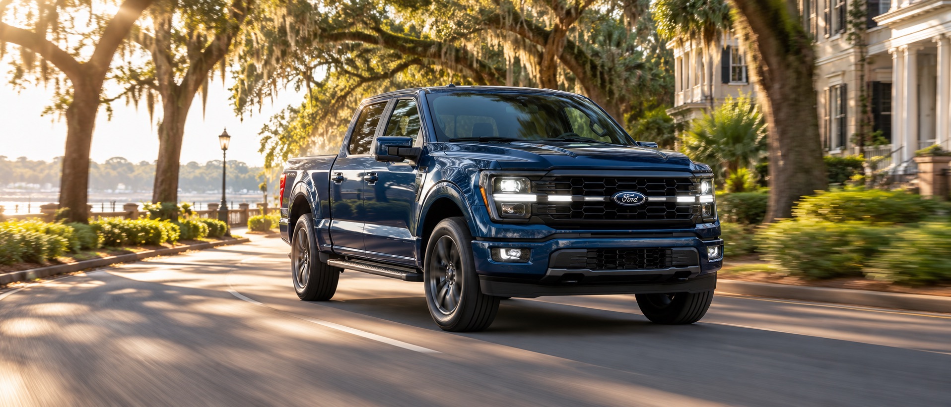 Deep blue Ford F-150 driving beneath Spanish moss-draped live oak trees in Savannah, Georgia